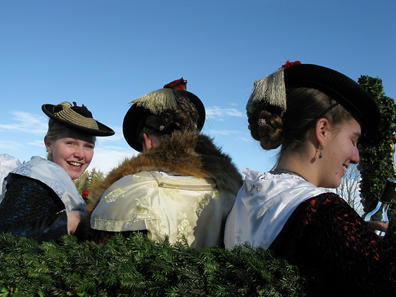 Junge Frauen im seidenen Mieder auf dem Truhenwagen auf der Tölzer Leonhardifahrt